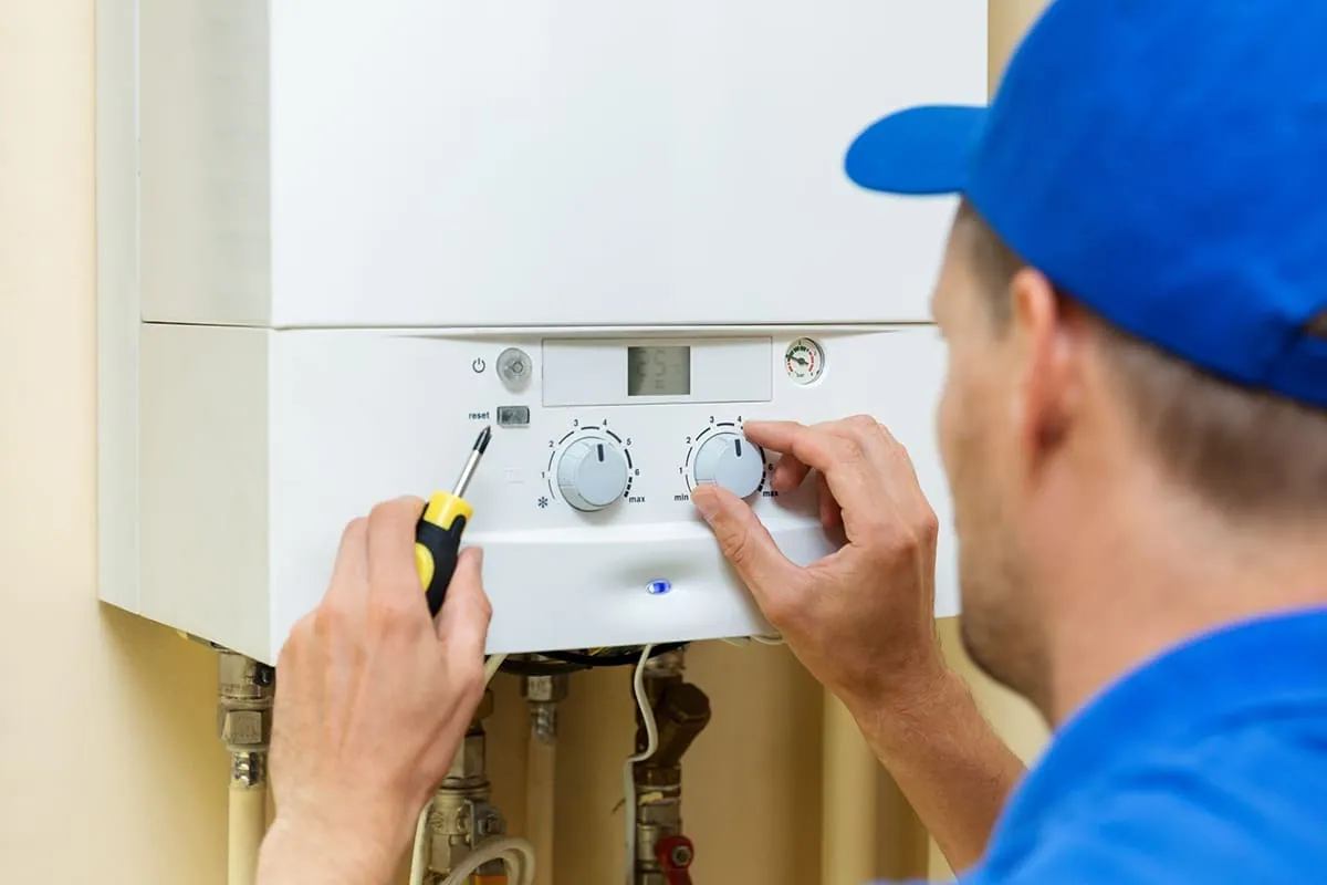 Técnico ajustando los mandos de un calentador de gas tras una reparación en Tenerife