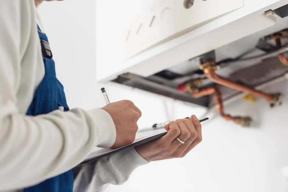 Técnico anotando los resultados de la revisión de un calentador de gas en Tenerife