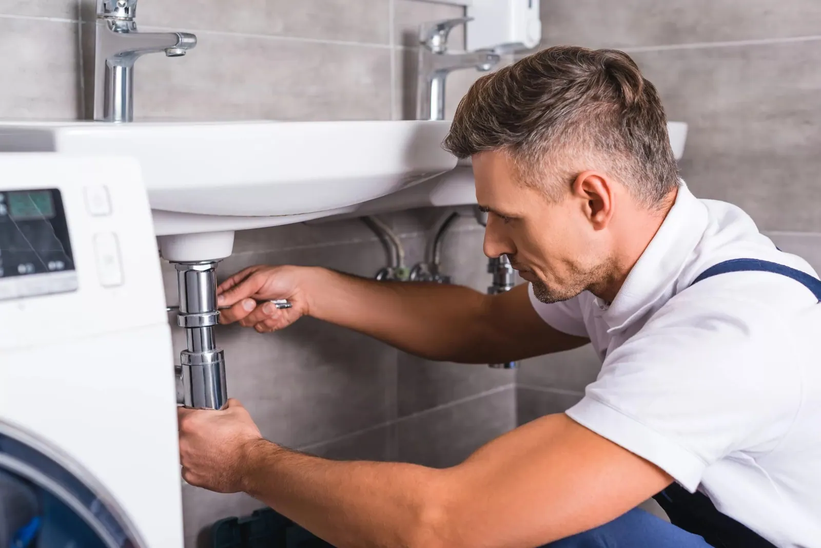 Fontanero desmontando el sifón de un lavabo en un desatasco básico en Tenerife