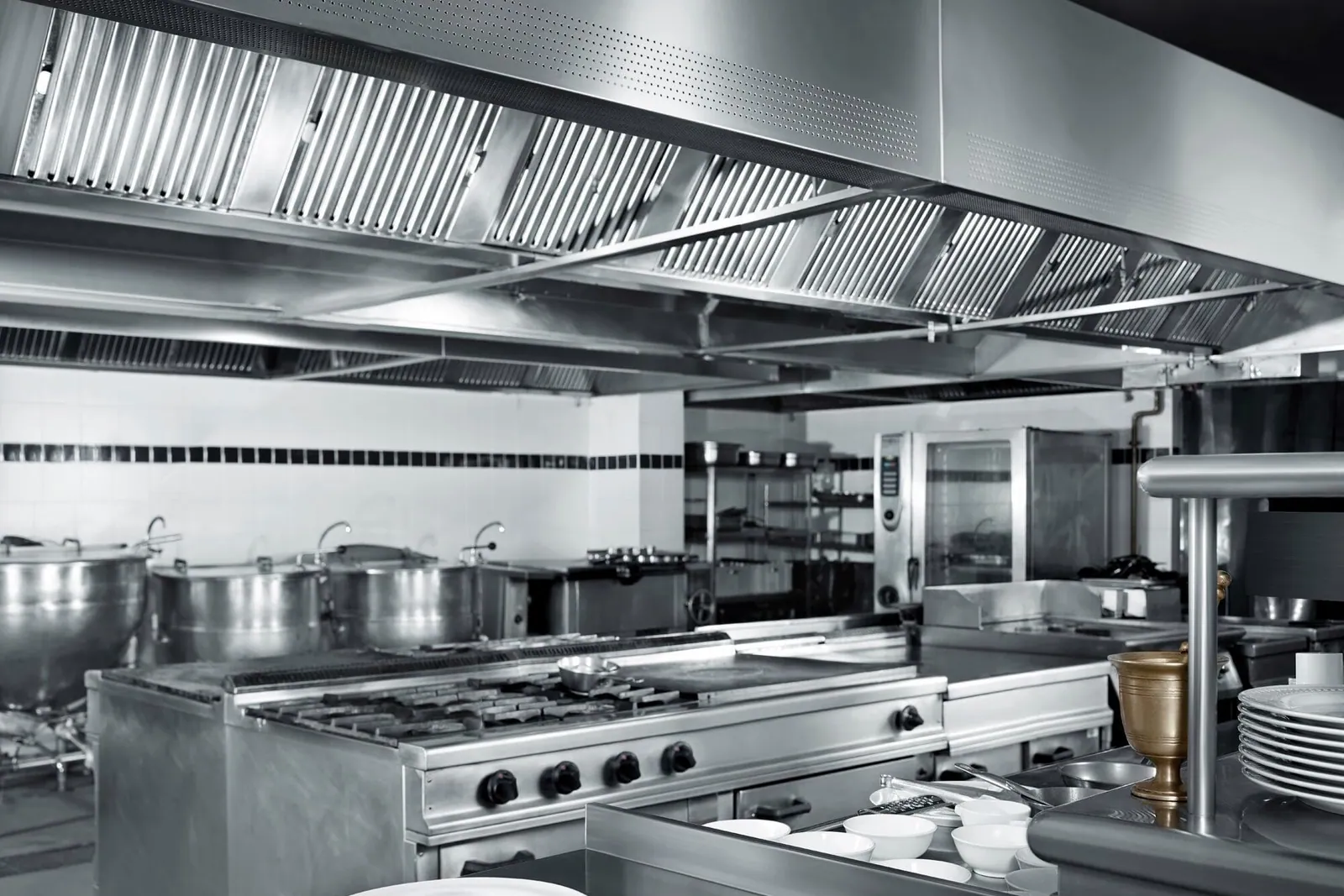 Cocina profesional con una campana extractora de acero inoxidable de gran tamaño sobre la zona de fogones