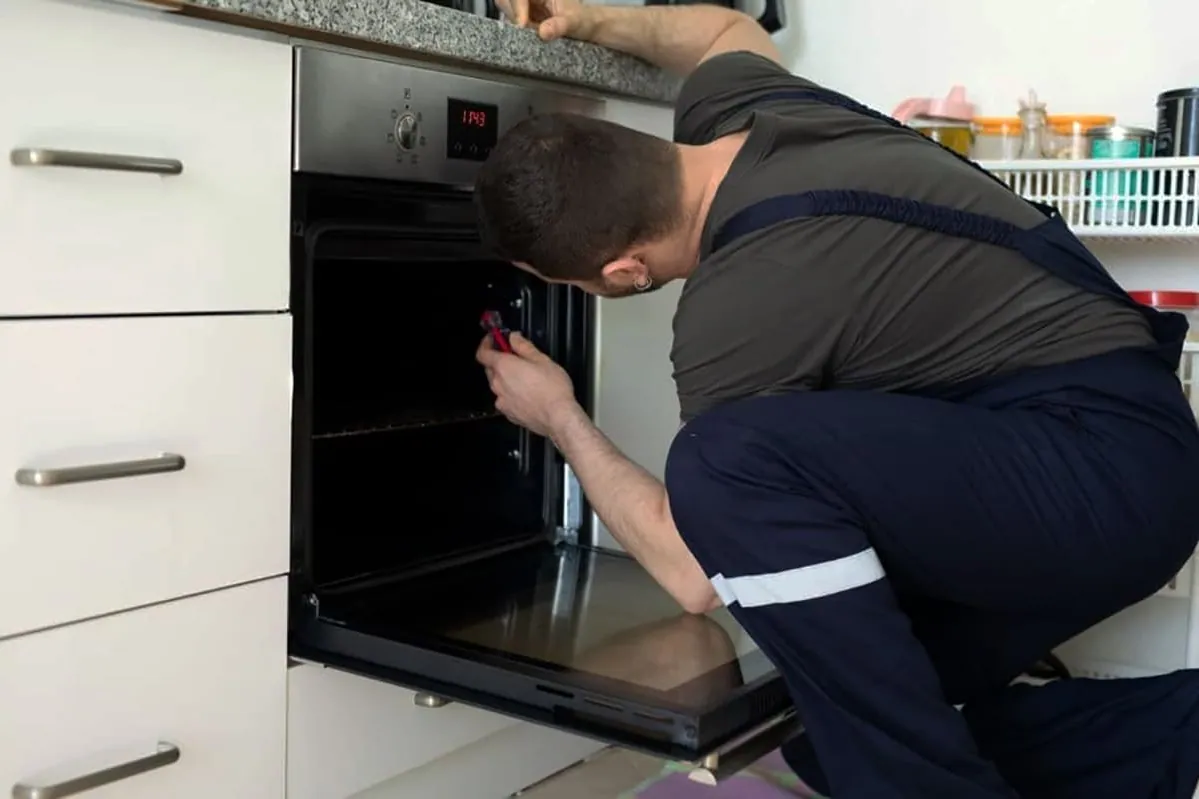 Revisión de la puerta de un horno: junta, bisagras y cristal durante una reparación