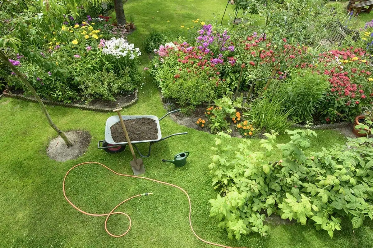 Jardín con parterres de flores y carretilla tras un mantenimiento en Gran Canaria