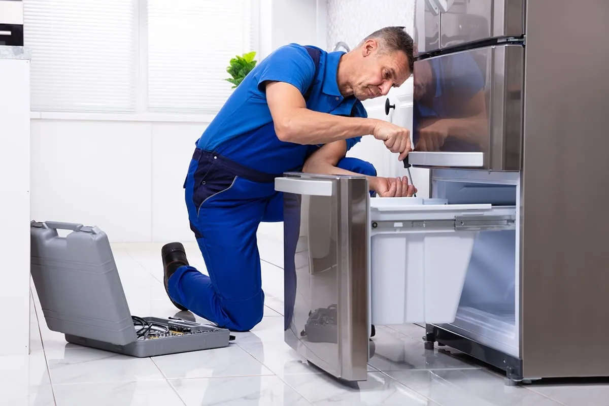 Técnico reparando una nevera en una cocina de Gran Canaria