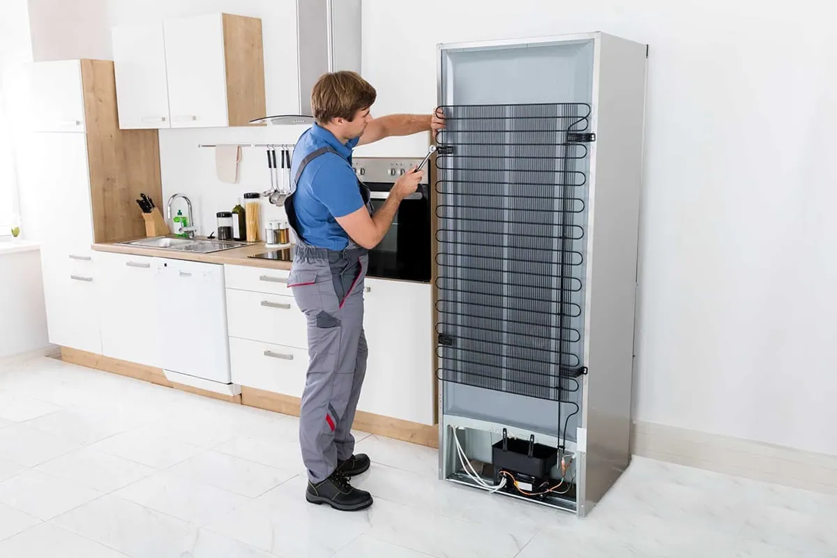 Técnico separando un frigorífico de la pared para revisarlo en una cocina de Tenerife