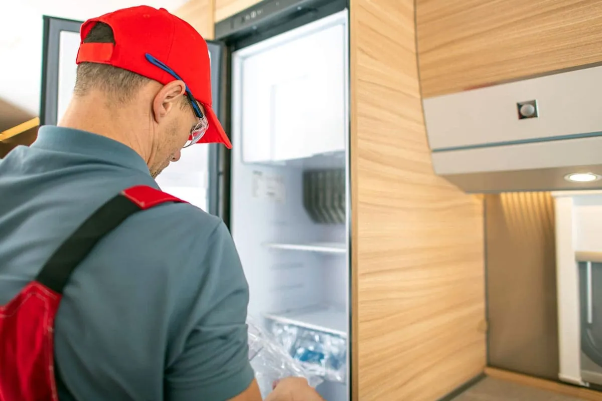 Técnico revisando el interior de una nevera durante una reparación en Gran Canaria
