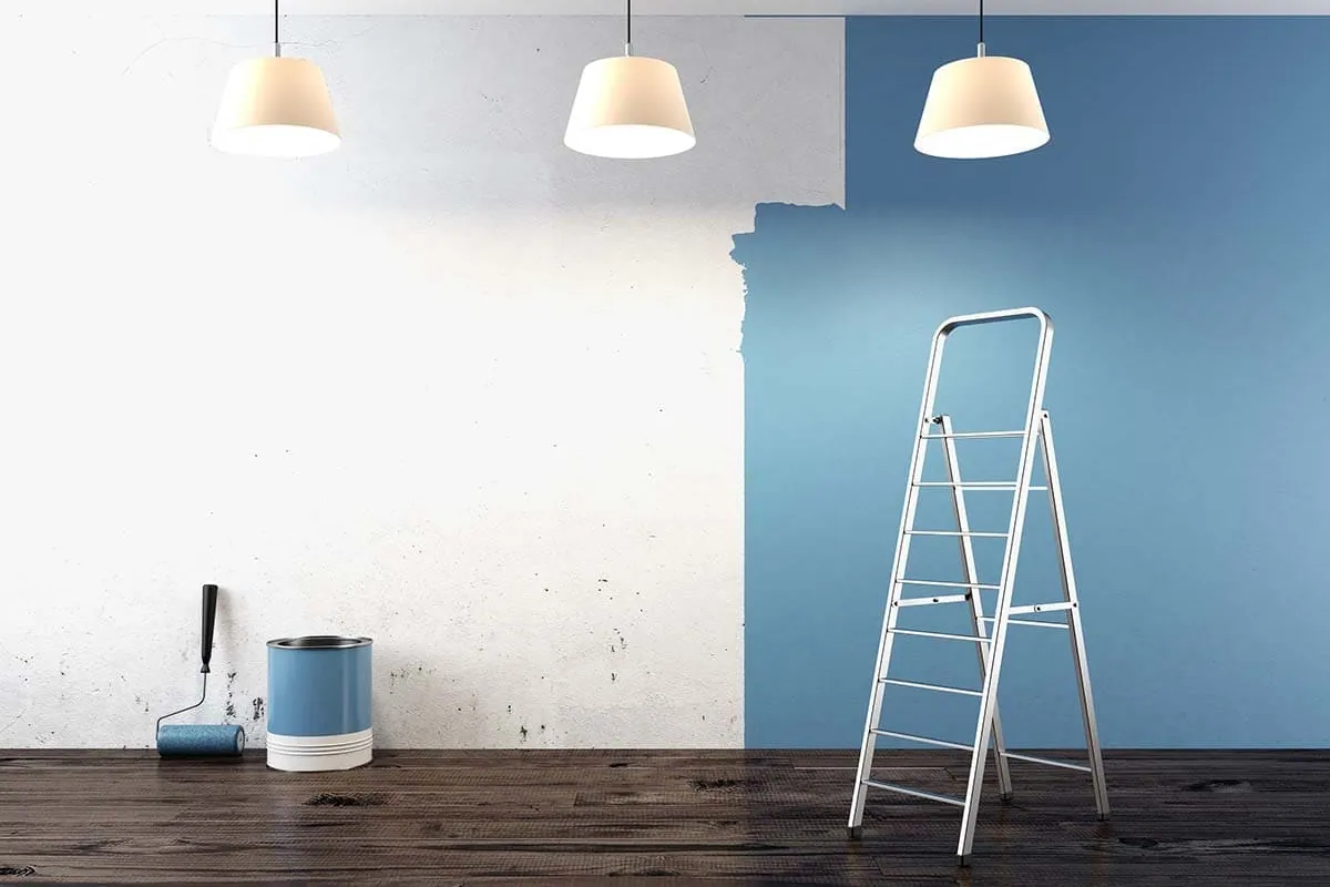 Pared a medio pintar con escalera y cubos durante un trabajo de pintura interior en Tenerife