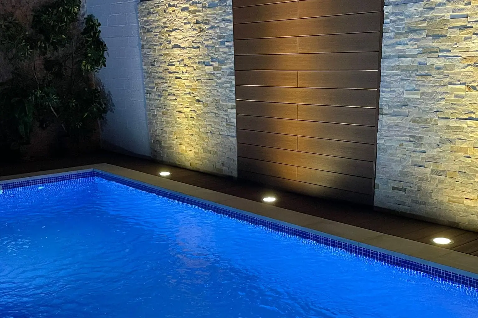 Piscina de obra iluminada de noche con focos sumergidos
