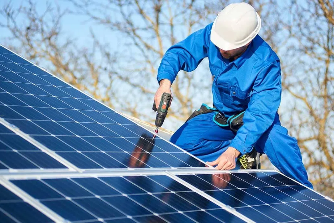 Instalador atornillando un panel solar en una cubierta de una vivienda en Gran Canaria