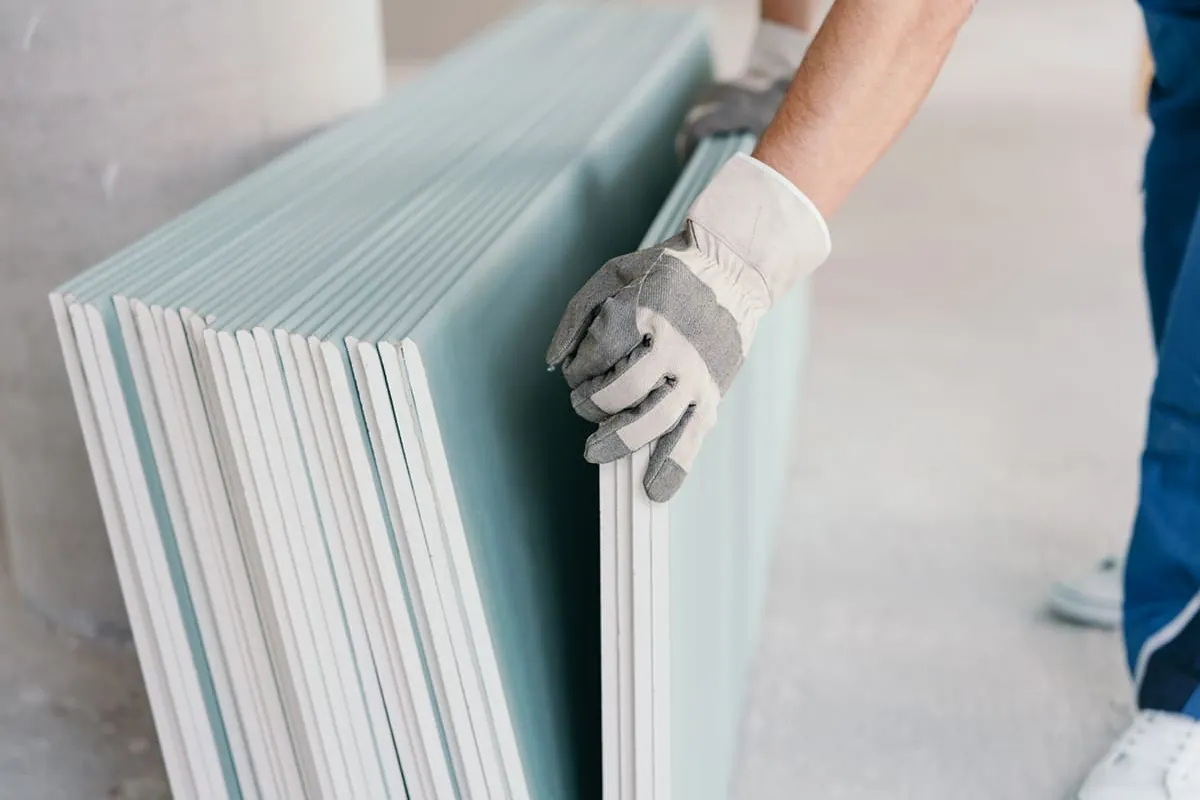 Placas de yeso laminado apiladas y listas para instalar en una reforma de vivienda