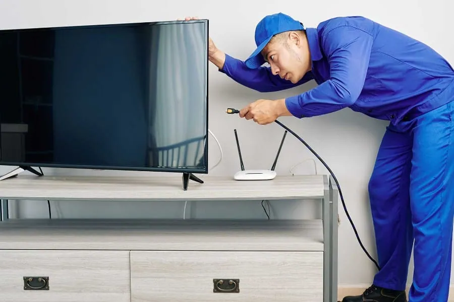 Técnico conectando un televisor tras su reparación en Tenerife