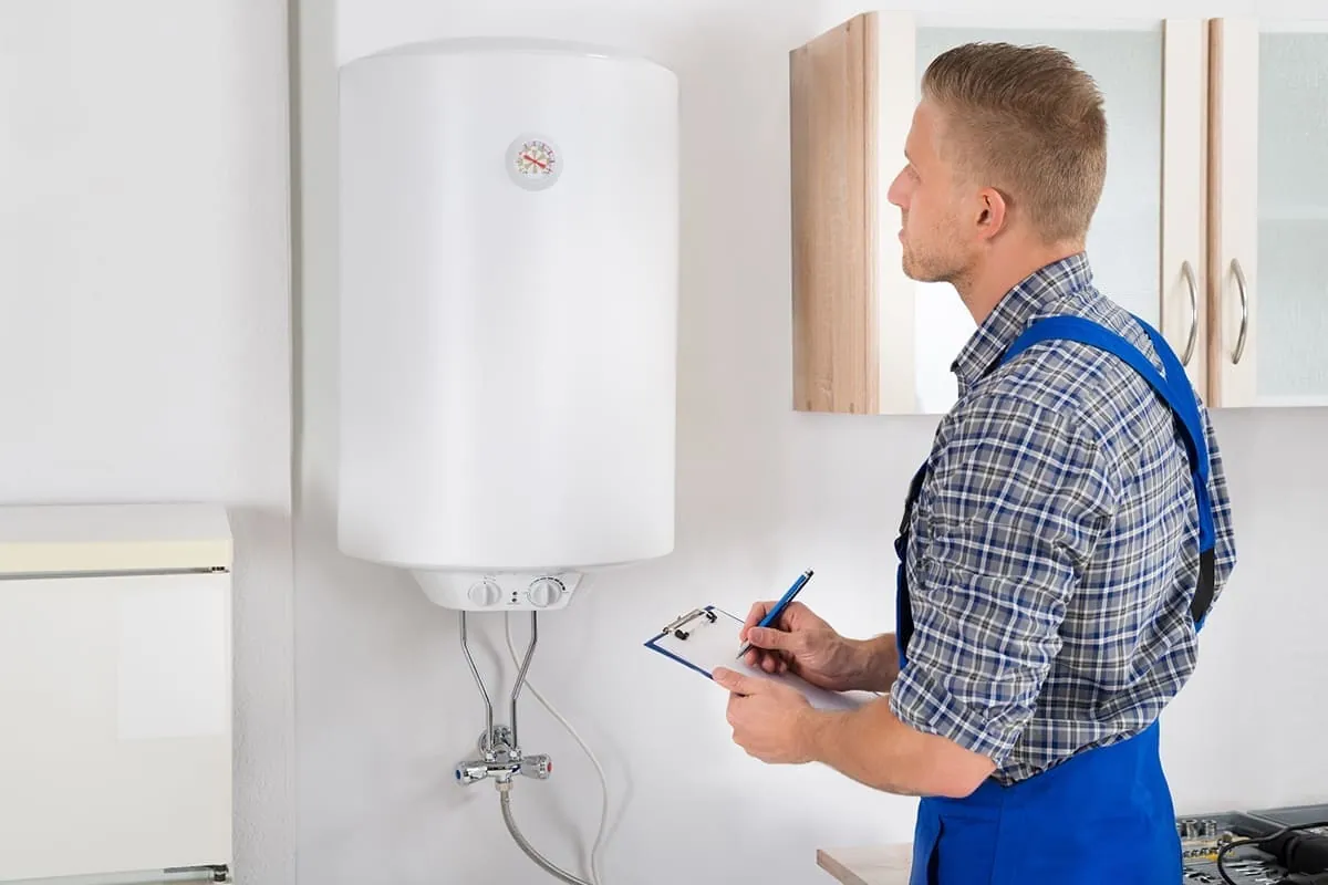 Técnico anotando la revisión de un termo eléctrico en una vivienda de Gran Canaria