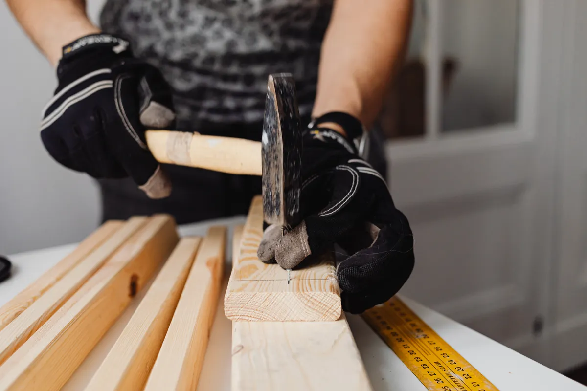 Artesano clavando clavos en la madera con un martillo