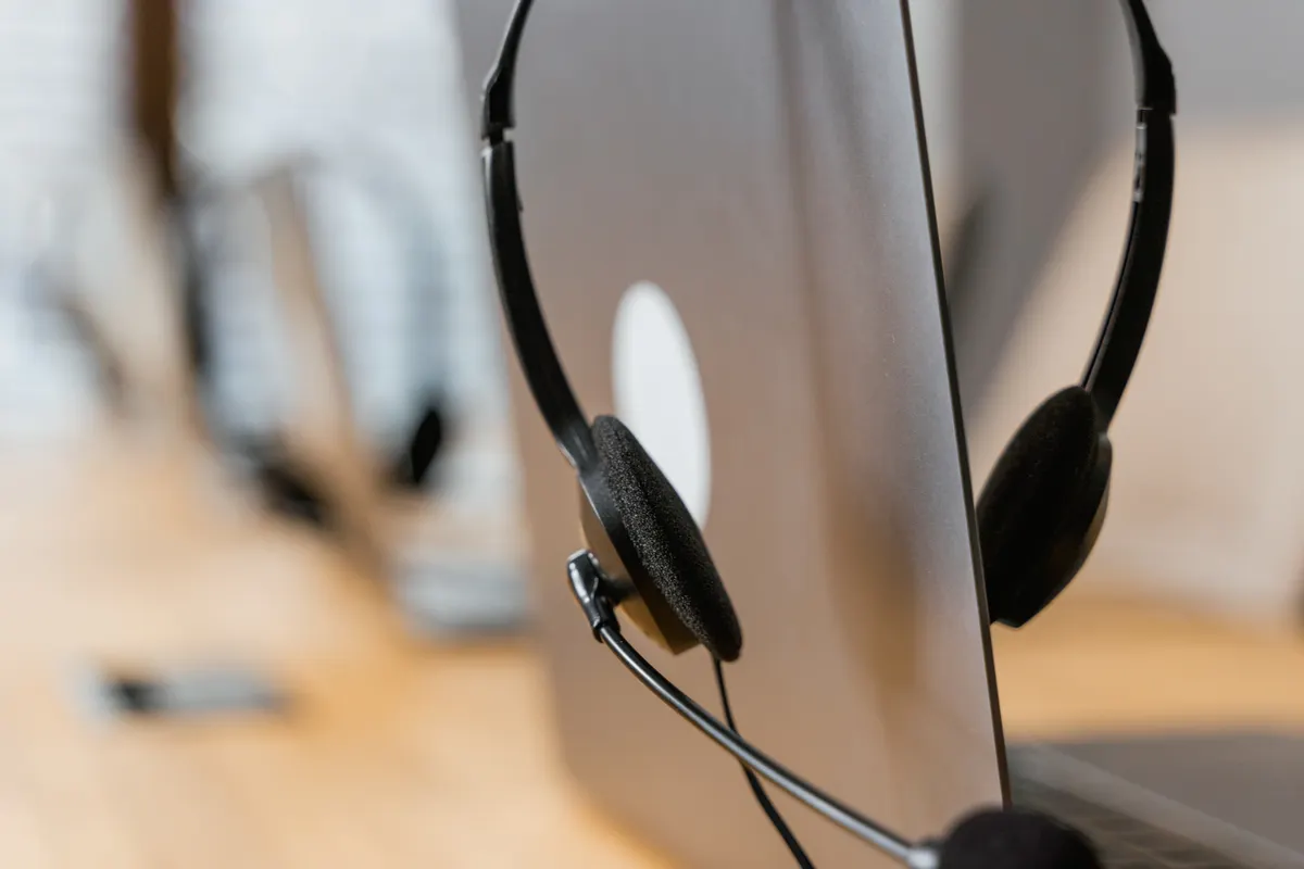 Auriculares con micrófono apoyados sobre un ordenador portátil