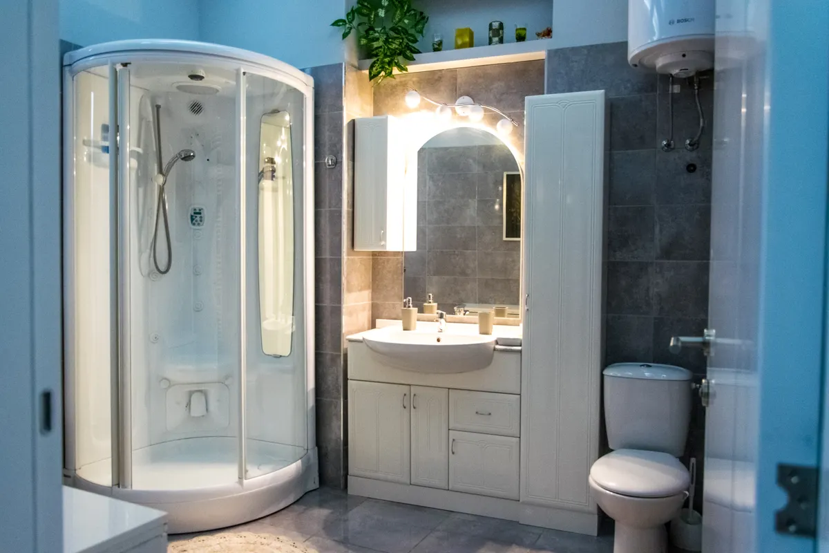 Baño con cabina de ducha, mueble de lavabo e inodoro