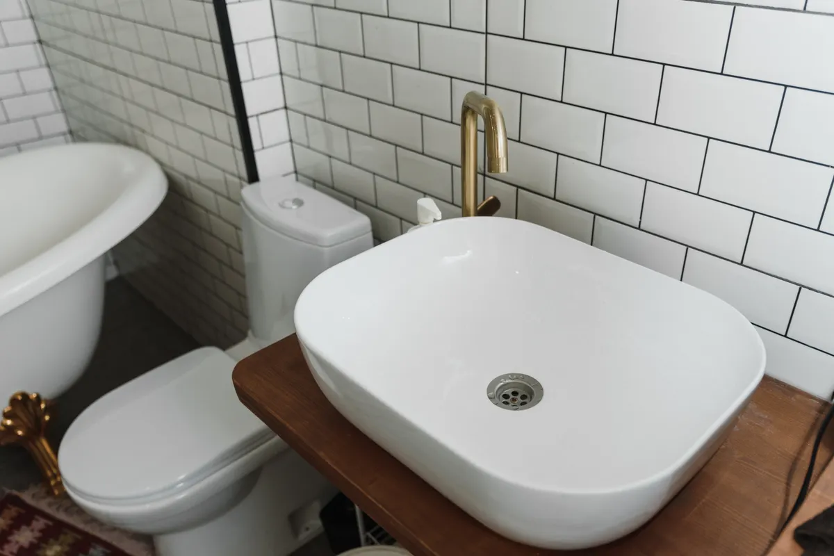 Baño con lavabo de cerámica, bañera y accesorios modernos