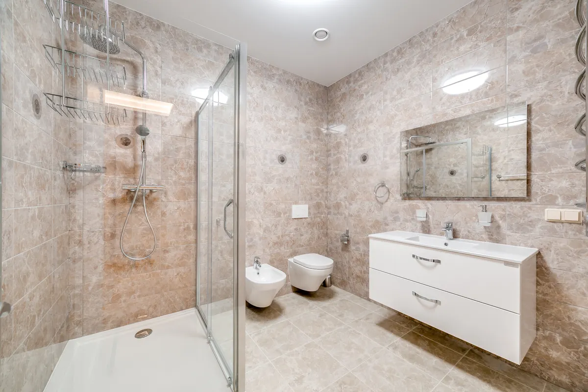 Baño minimalista con ducha acristalada y grifería de diseño