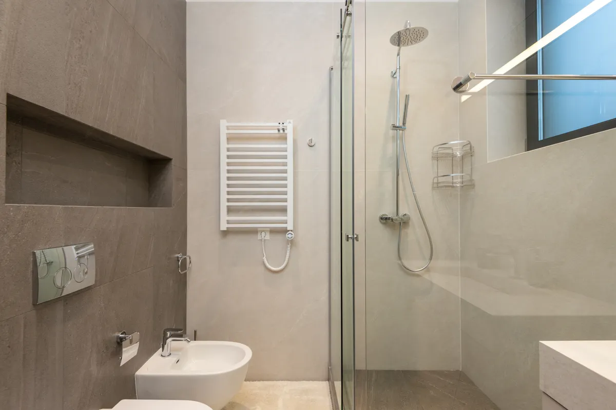 Baño moderno con cabina de ducha de cristal, inodoro y bidé