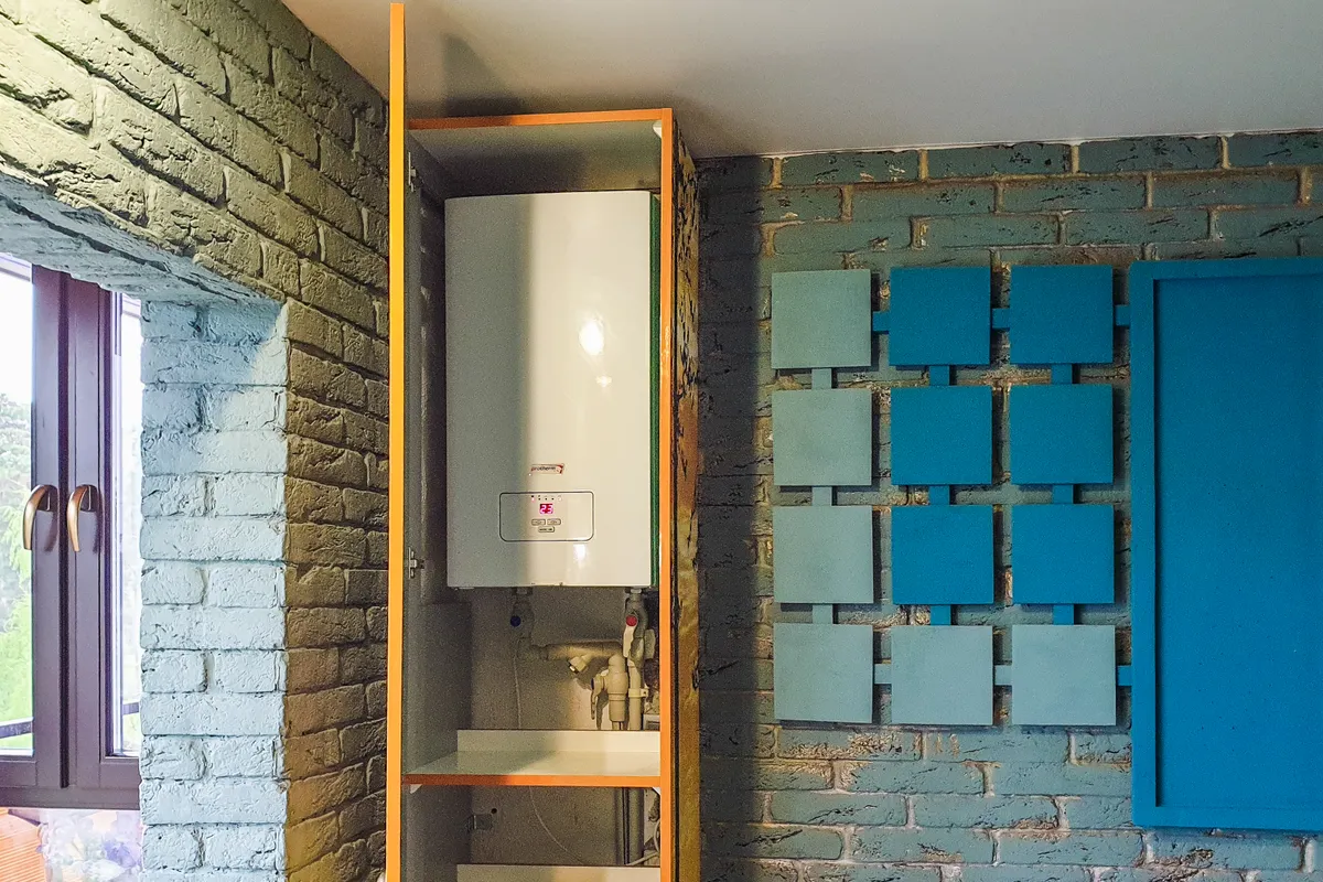 Calentador de agua instalado dentro de un armario en un interior de decoración moderna