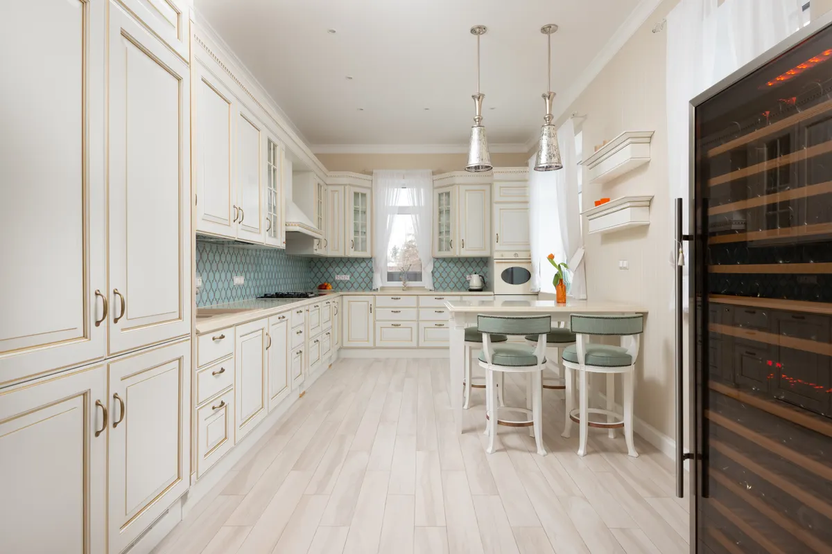 Cocina clásica blanca con una vinoteca alta de puerta de cristal llena de botellas