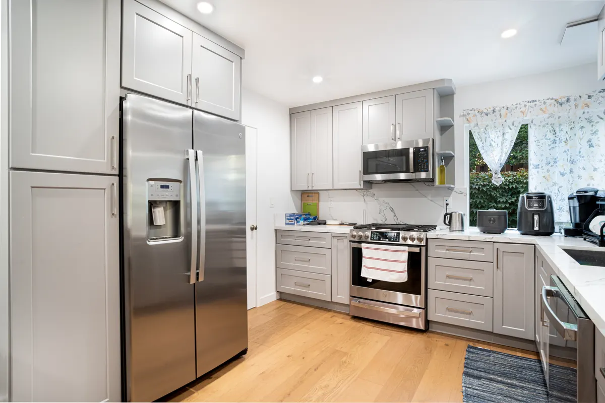 Cocina contemporánea con electrodomésticos de acero inoxidable y muebles lisos