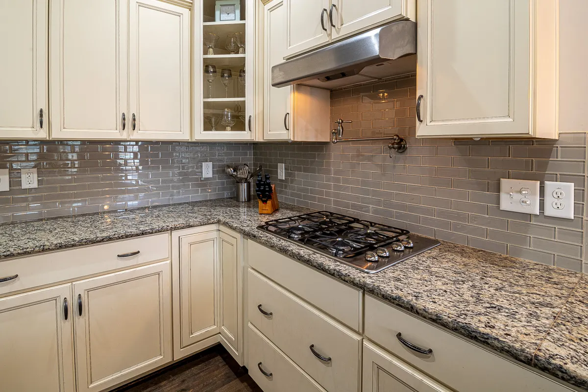 Cocina de diseño con encimeras de granito, fogones de acero inoxidable y muebles modernos