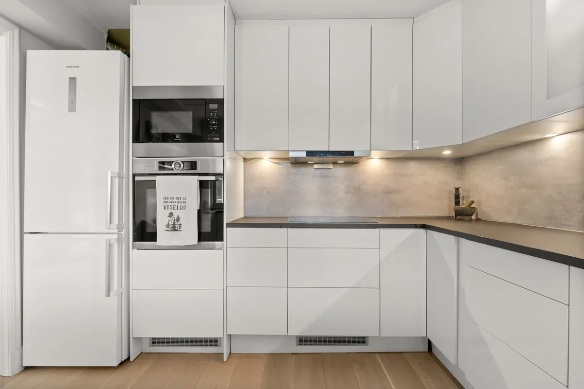 Cocina moderna de diseño minimalista con muebles blancos y electrodomésticos empotrados