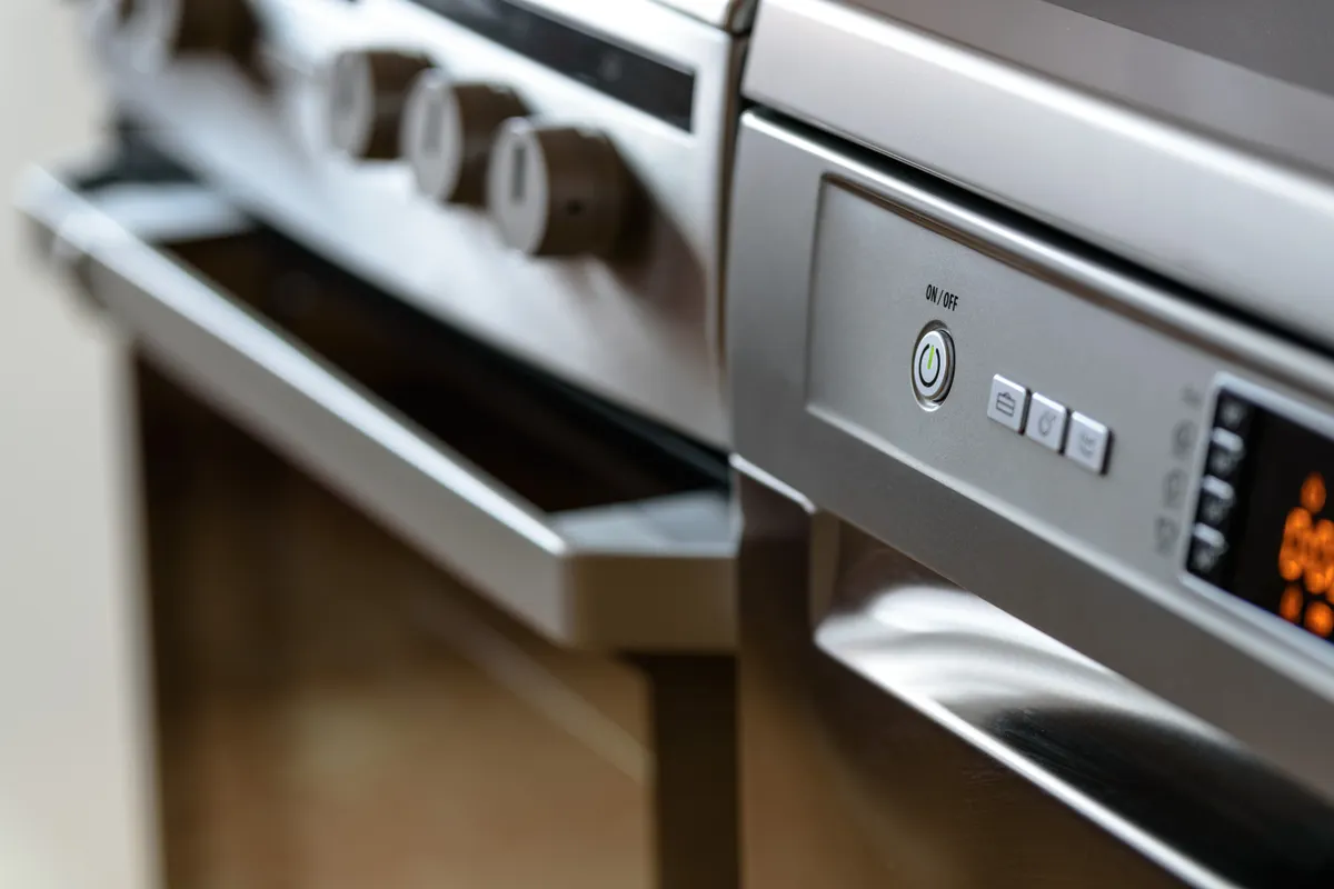 Electrodomésticos de acero inoxidable con el lavavajillas y el horno en primer plano