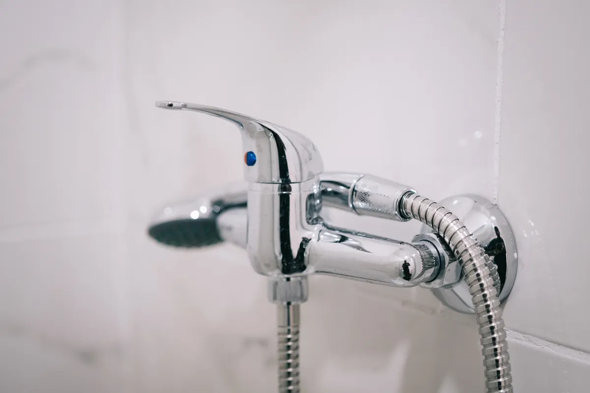 Grifo de ducha cromado en un cuarto de baño limpio