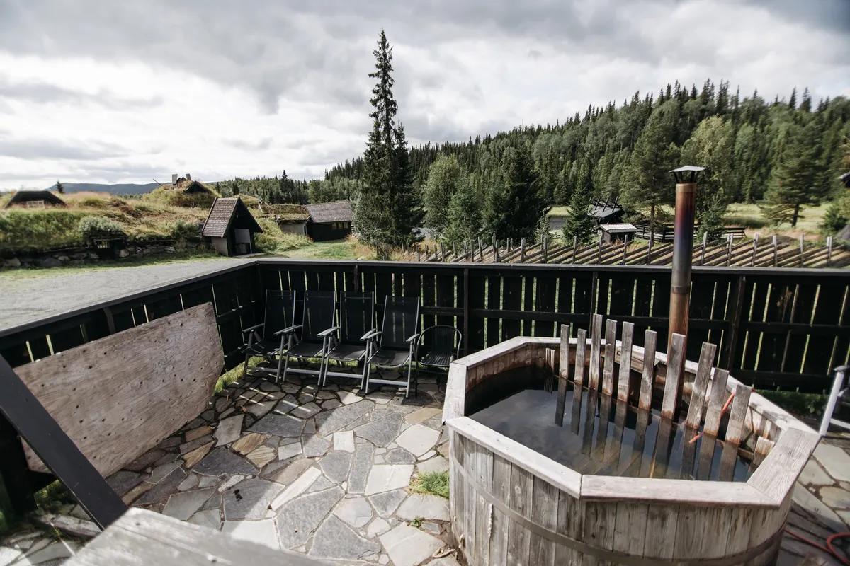 Jacuzzi de madera en un patio rural con vistas al bosque