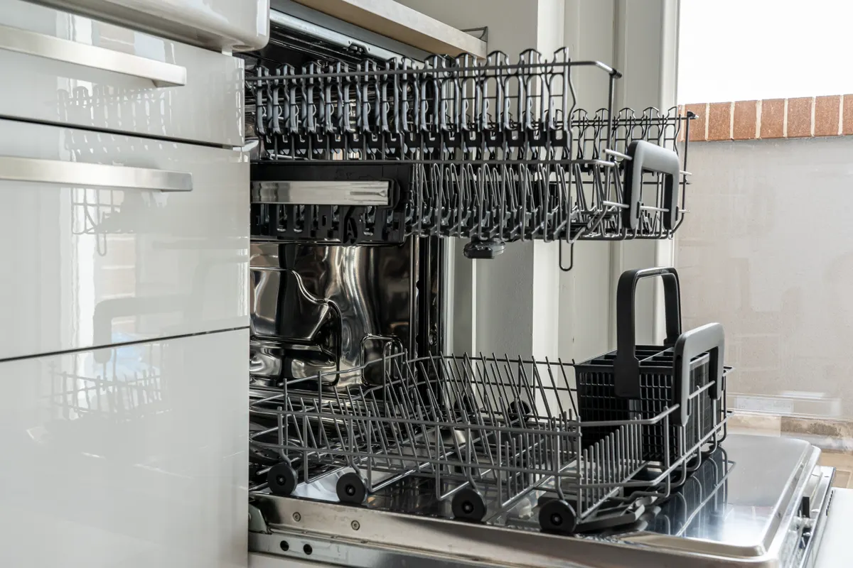 Lavavajillas abierto y vacío en una cocina moderna con luz natural