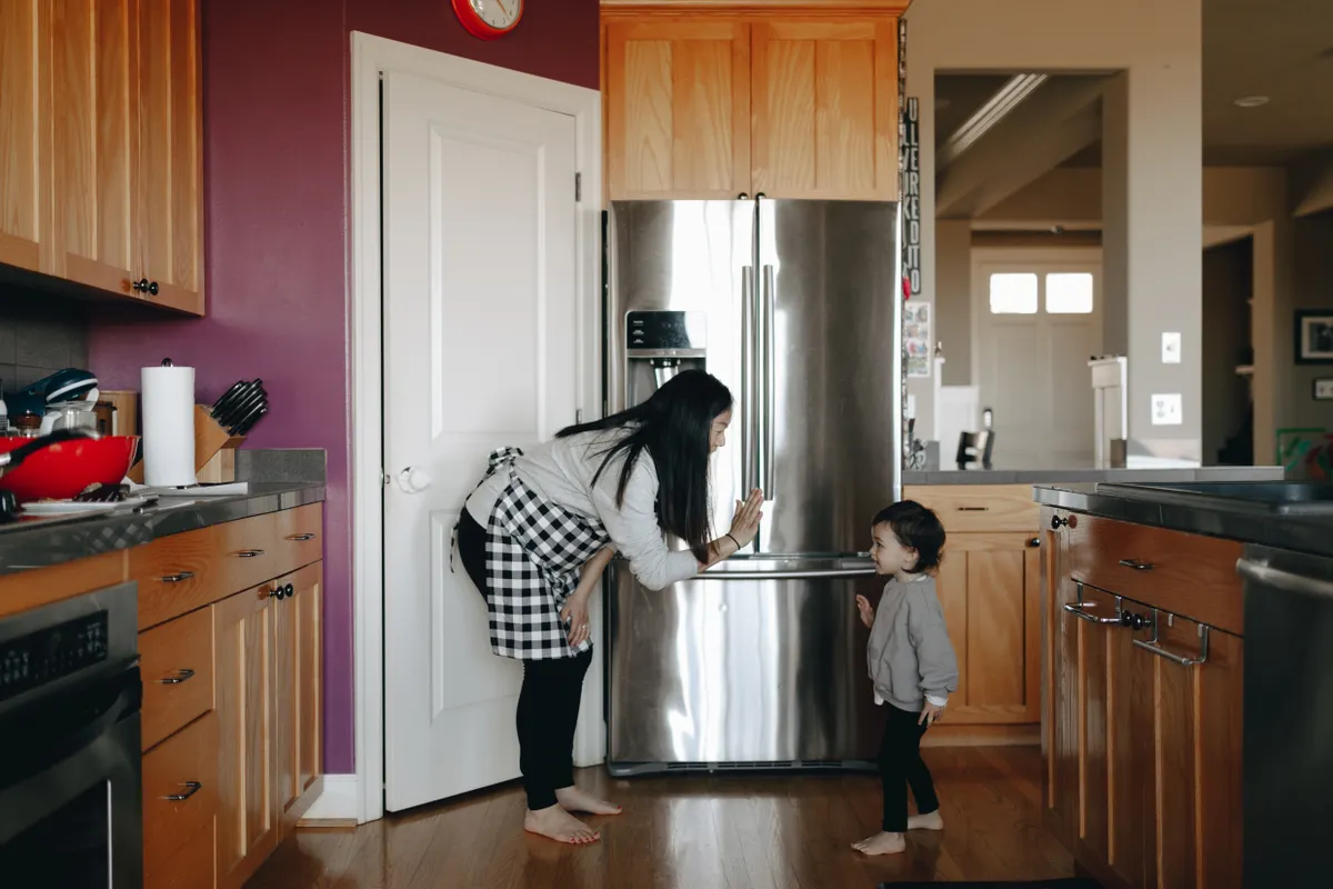 Madre compartiendo un momento con su hijo en una cocina moderna y acogedora