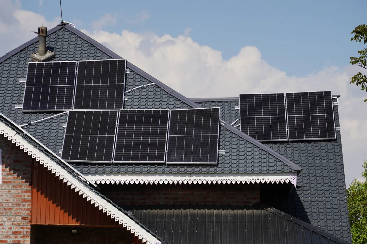 Placas solares en el tejado de una casa con el cielo azul de fondo