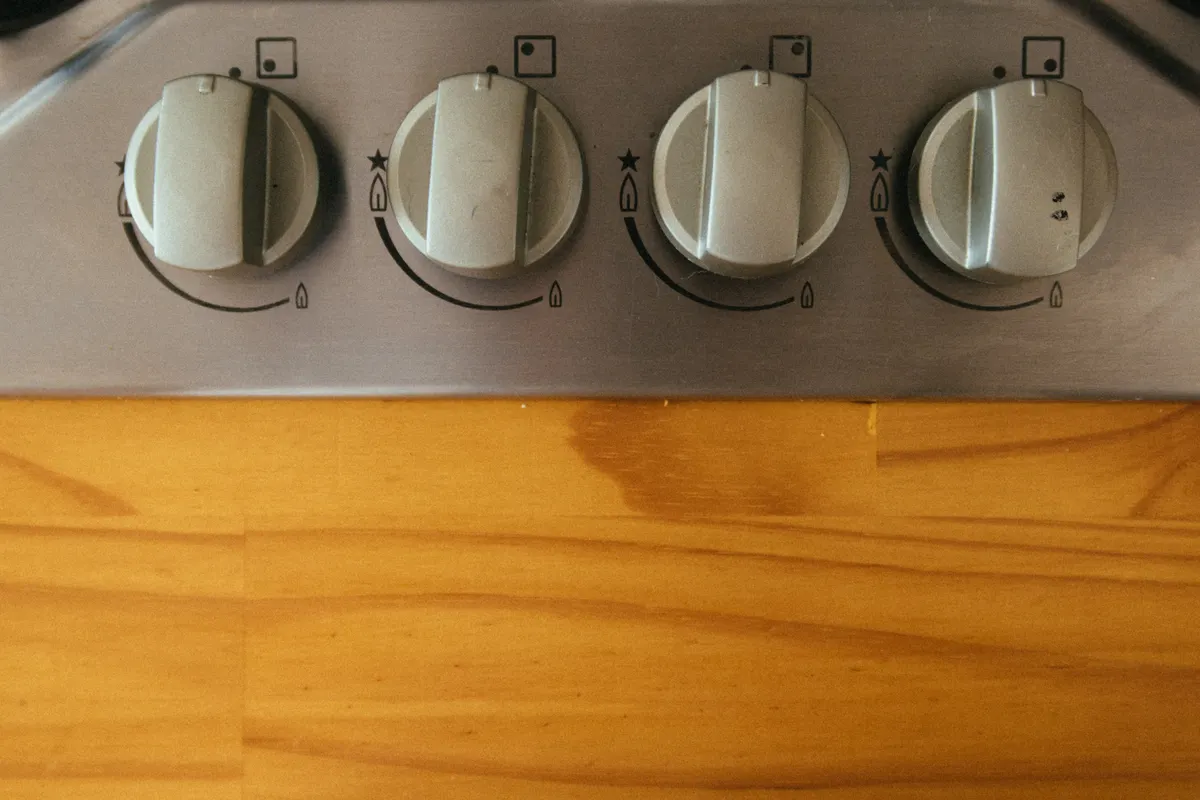Primer plano de los mandos de una cocina moderna sobre una encimera de madera