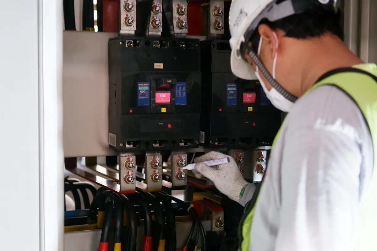 Técnico con equipo de seguridad revisando cuadros eléctricos en una instalación industrial