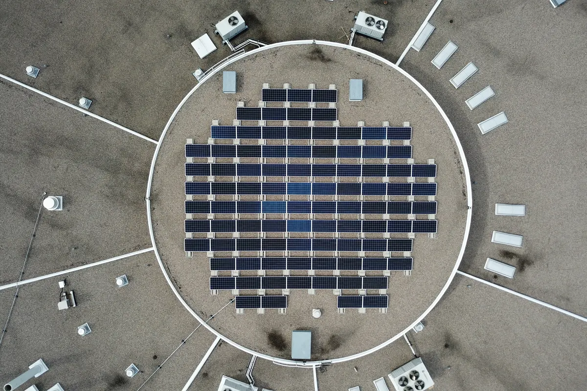 Vista aérea de placas solares dispuestas en cuadrícula sobre una cubierta