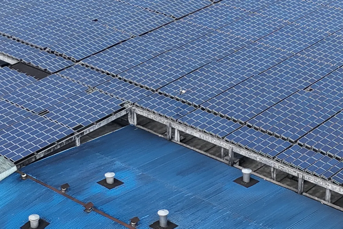Vista aérea de placas solares instaladas sobre una cubierta industrial azul