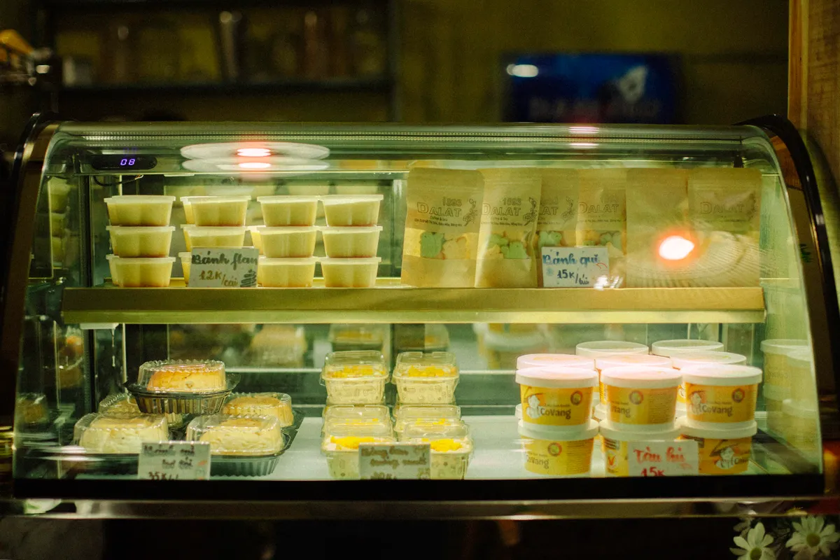 Vitrina iluminada de pastelería llena de dulces y productos envasados